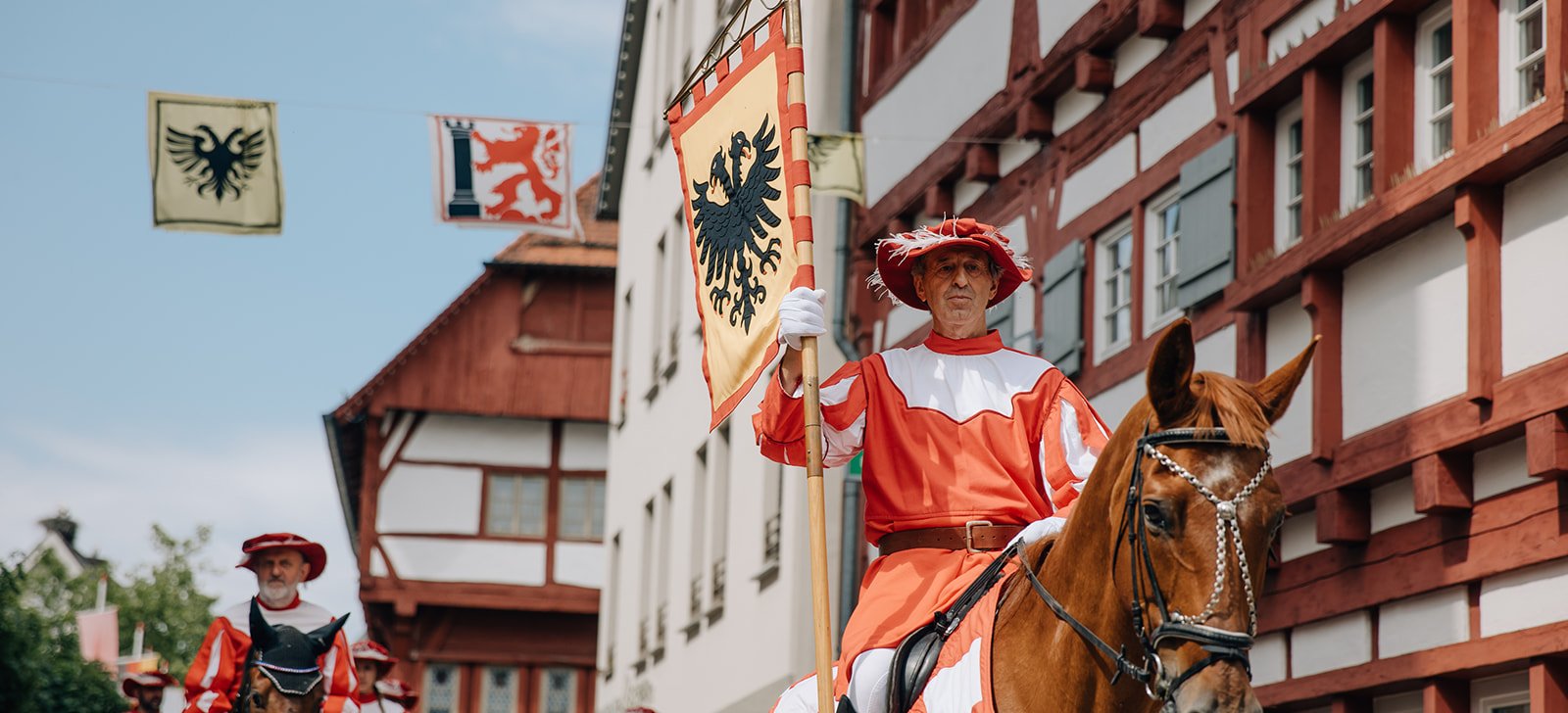 Verkleidete Männer auf Pferden.