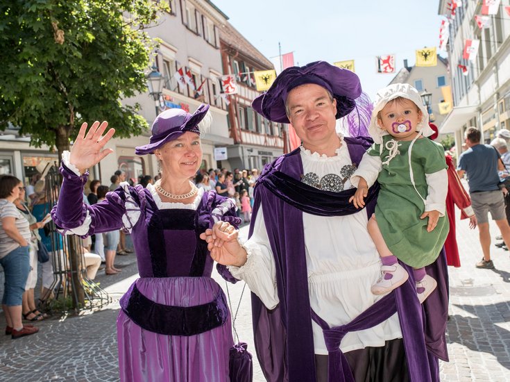 Historisch verkleidetes Paar mit einem Kleinkind während des Umzugs zum Bächtlefest