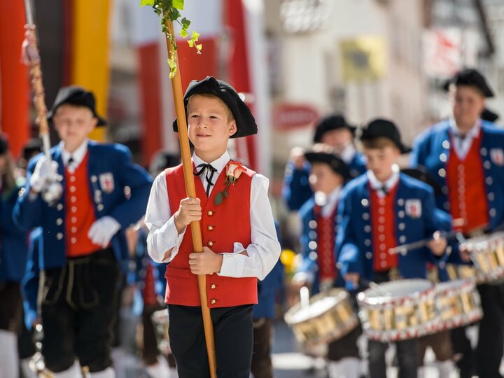 Fahnenträger und Trommler ziehen beim Festumzug des Bächtlefests durch die Straße