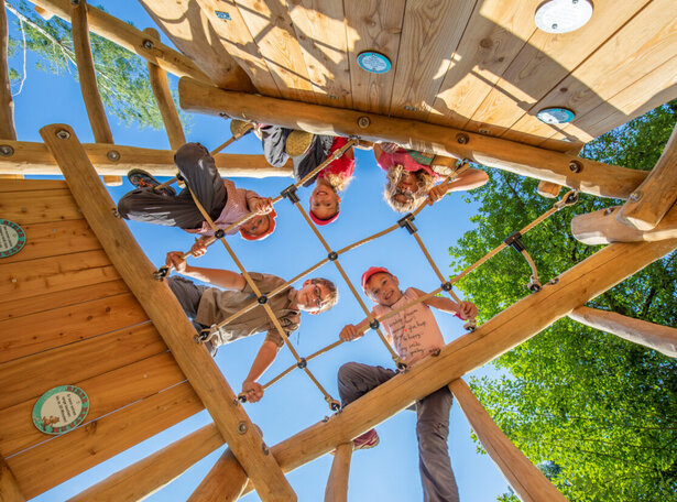 Kinder auf einem Holzspielgerät