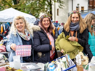 Drei Frauen bei einem Flohmarkt.